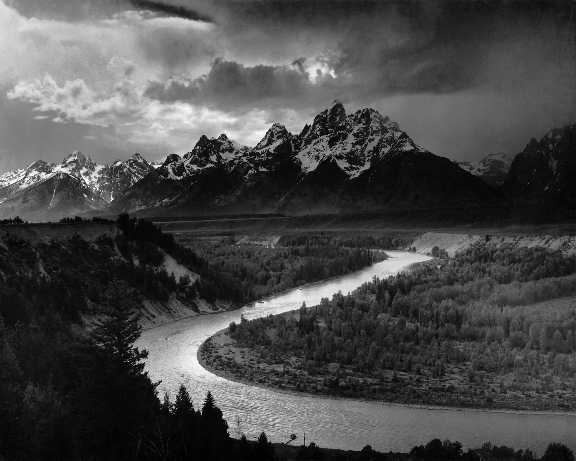 Black-and-white photograph of the Snake River winding below the jagged Teton range