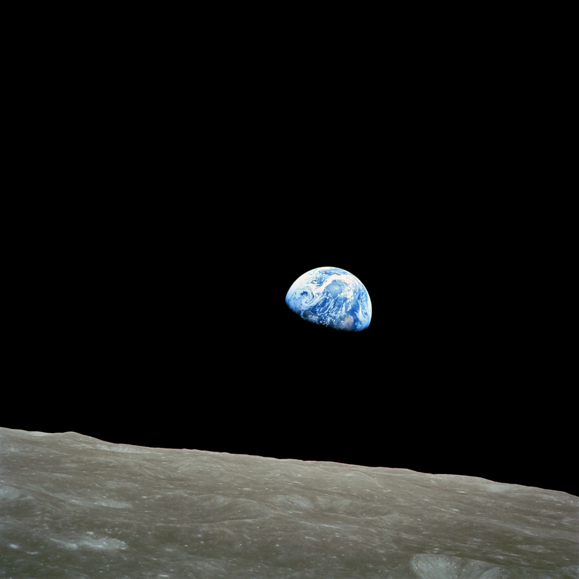 Earth rising over the grey lunar horizon, seen from Apollo 8
