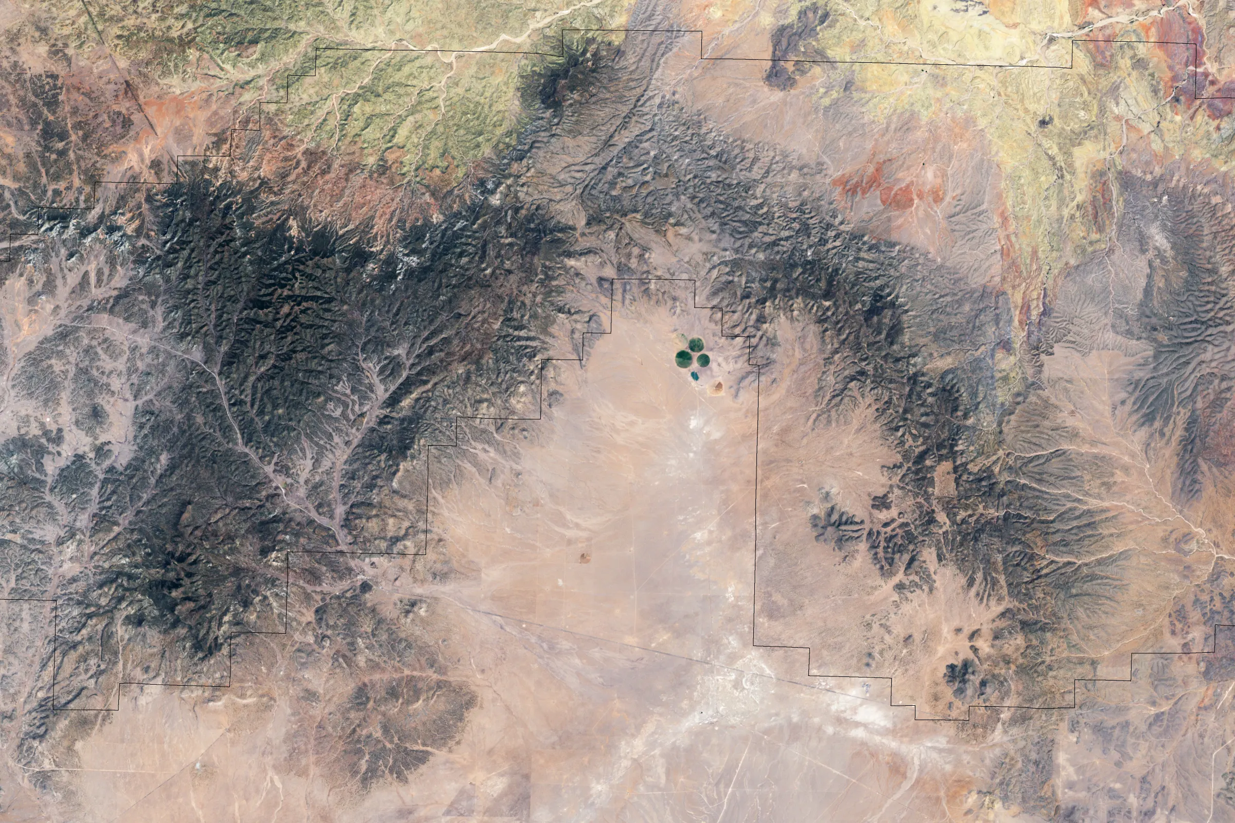 Aerial view of the Y-shaped Very Large Array spread across a pale desert plain